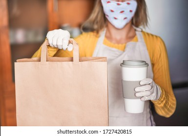 Young Woman Wearing Face Watermelon Mask While Serving Takeaway Food And Coffee Inside Bar Cafeteria - Worker Preparing Healthy Organic Food Inside Cafe' Kitchen During Quarantine - Focus On Left Hand