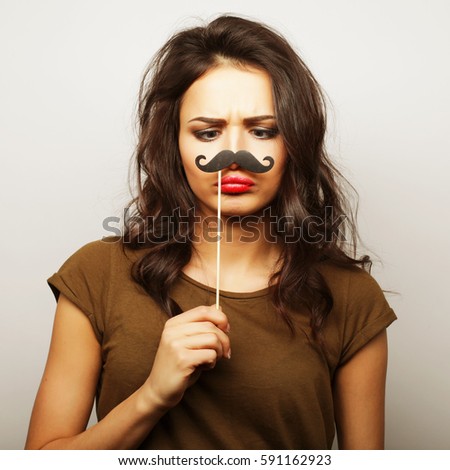 Young woman wearing fake mustaches. Ready for party.
