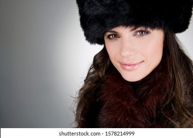 A young woman wearing a fur hat, smiling