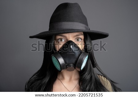 Young woman wearing a gas mask and wide-brimmed hat.  Air pollution Future Concept