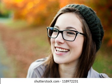 Young woman wearing glasses laughing in the fall