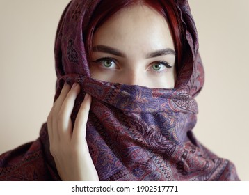 Young woman wearing hijab on light background.
