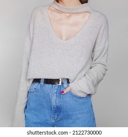 Young Woman Wearing A Light Sweater And Blue High-waisted Mom Jeans Isolated On White Background