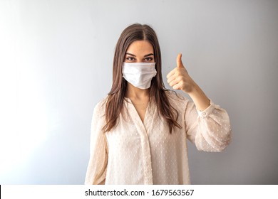 Young woman wearing medical face mask, studio portrait. Woman Wearing Protective Mask and Showing OK sign. Woman wearing surgical mask for corona virus.  - Shutterstock ID 1679563567