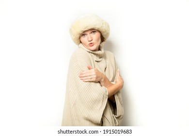 Young Woman Wearing Poncho And Ushanka On White Snow Backdrop