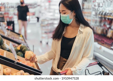 Young Woman Wearing Protect Face Mask Shopping In Supermarket. Asian Woman Wearing Medical Mask Shopping In Grocery Store During Coronavirus Pandemic.  Coronavirus Crisis, Covid19 Outbreak.