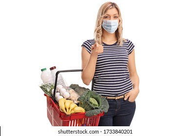 Young Woman Wearing A Protective Face Mask And Carrying A Shopping Basket Isolated On White Background