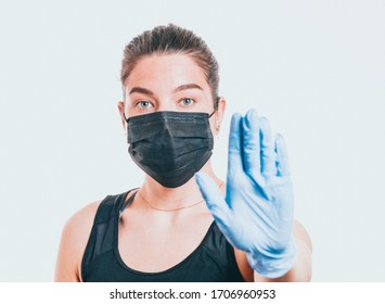 Young woman wearing protective mask on face and medical gloves. Showing stop sign. Confident girl, female doctor in medical mask and protective gloves. Coronavirus COVID-19 protection. - Powered by Shutterstock