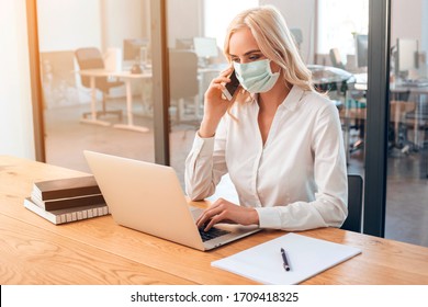 Young Woman Wearing Protective Mask On Her Face During Coronavirus Epidemic At Work. Office Photography