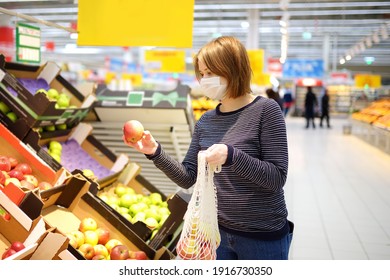 Young woman wearing protective medical face mask shopping in supermarket during coronavirus pneumonia outbreak. Social distancing restrictions and facemask - measures safety while covid-19 pandemic