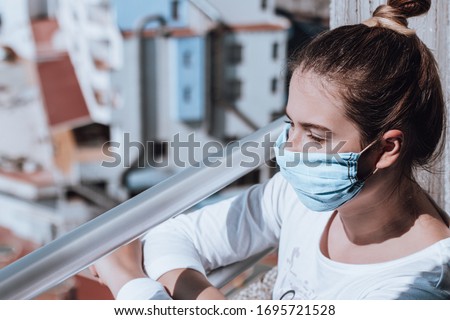 Young woman wearing protective selfmade mask due to medical mask shortage at quarantine. Closeup portrait of a woman self isolated during covid pandemic.