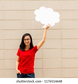 Young Woman Wearing Red T Shirt Holding A Speech Bubble On Brick Wall Background