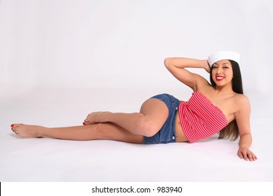 Young Woman Wearing Sailor Hat Laying Down On Her Side.