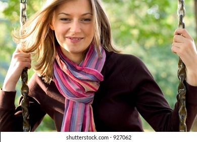 Young woman wearing a scarf on a swing.