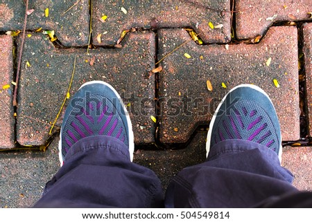 Young woman wearing sport shoes standing on orange old brick considering which way to choose