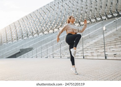 Young woman wearing sports clothes warming up before jogging on the street. People, sport, fitness and flexibility concept - Powered by Shutterstock