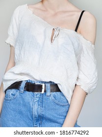 Young Woman Wearing Stylish Outfit With Linen Shirt And Blue High-waisted Mom Jeans Isolated On Light Grey Background. Copy Space