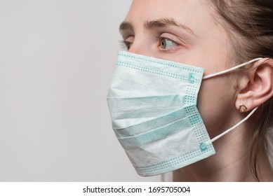 Young Woman Wearing Surgical Mask With Ear Rubber Straps. Portrait Close Up Side View.