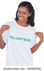 Young Woman Wearing Volunteer Tshirt And Pointing To It On White Background