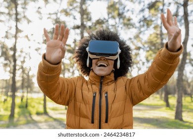 Young woman wearing a VR headset, laughing and enjoying a virtual reality experience in the forest. - Powered by Shutterstock