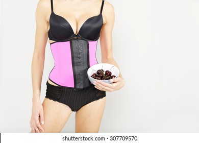 Young woman wearing a waist training corset in black underwear which is the new craze for looking slim