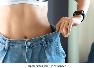 Young woman wearing white clothes showing loose pants after losing weight Ideas for exercise, fitness, food, gym, exercise, lifestyle and healthy ideas.