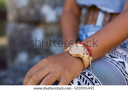young woman wearing a wooden watch