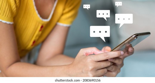 Young Woman Wearing A Yellow T-shirt Sitting On Sofa Using A Smartphone Hand Touching On Screen With A Chat Icon Show That She Is Interacting With Close Friends Or Talking About Work.