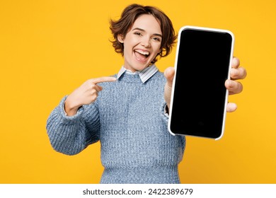 Young woman wears grey knitted sweater shirt casual clothes hold in hand use point finger on mobile cell phone with blank screen workspace area isolated on plain yellow background. Lifestyle concept - Powered by Shutterstock