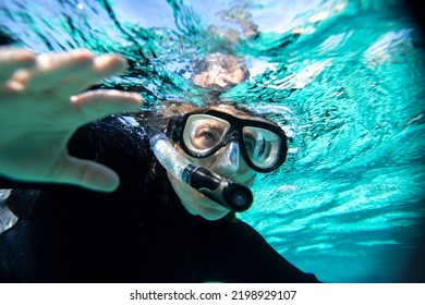 Young Woman In Wet Suit Snorkling Off The Coast Of Hopkins In Belize