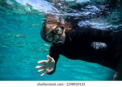 Young Woman In Wet Suit Snorkling Off The Coast Of Hopkins In Belize