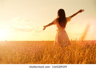 Young Woman In Wheat Field At Sunset