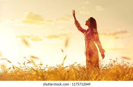 Young Woman In Wheat Field At Sunset