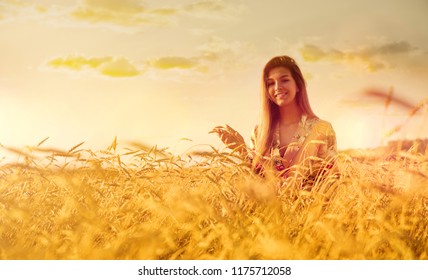 Young Woman In Wheat Field At Sunset