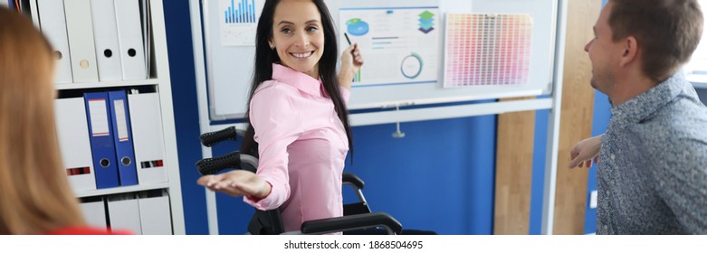 Young Woman In Wheelchair Teaches Group Of Business People At Blackboard In Office. Personal Growth Leadership Disabled People Concept.