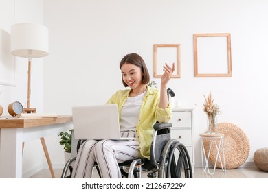 Young Woman In Wheelchair Using Laptop At Home