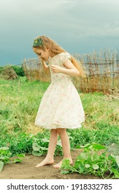 Young Woman In White Dress Relaxing In Apple Tree Garden. Girl With Bare Feet In Summer