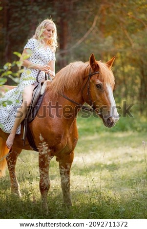 A young woman in a white dress riding a horse, riding a horse in the woods, a young woman with blonde hair.