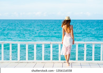 Junge Frau in weißem Kleid, Meer und heller Himmel auf dem Hintergrund
