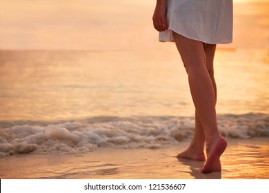 Young woman in white dress walking alone on the beach in the sunset - Powered by Shutterstock