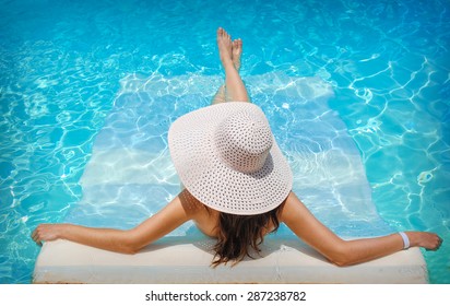 Young Woman In White Hat Resting In Pool.