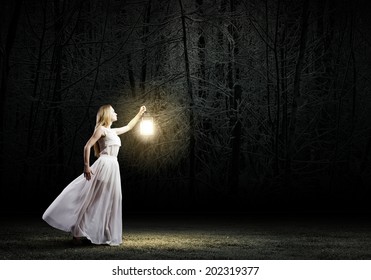 Young Woman In White Long Dress Walking In Night Wood