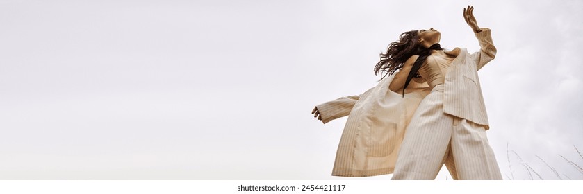 A young woman in a white outfit gracefully flying through the air, enjoying the summer breeze in a natural setting. - Powered by Shutterstock