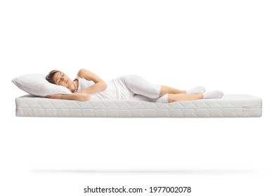 Young woman in white pajamas sleeping on a floating mattress isolated on white background - Powered by Shutterstock