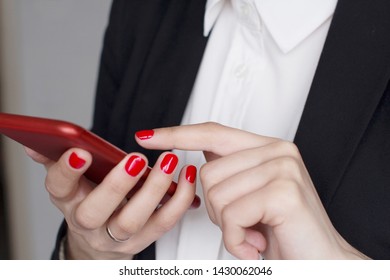 young woman in white shirt and black suit using a smart phone in red case - Powered by Shutterstock