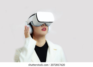 Young Woman With White Vr Goggles Head Set In The Concept Of Metaverse Idea Visual Share Space, For Game Or Movie.