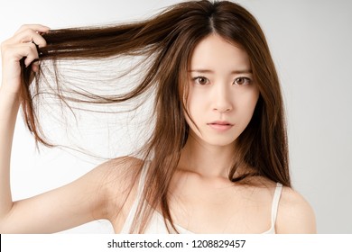 Young woman who be troubled by split ends. damaged hair. beauty and hair care concept.