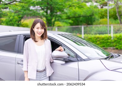 Eine junge Frau, die ihr eigenes Auto gekauft hat