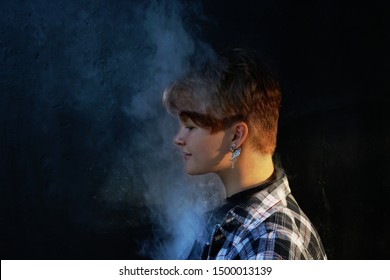 Young Woman Who Are Secretly Smoking At School. Smoking Girl.Vape Party. Sexy Young Woman With Glamorous Mystical Makeup Vaping In Nightclub (exhaling Smoke)