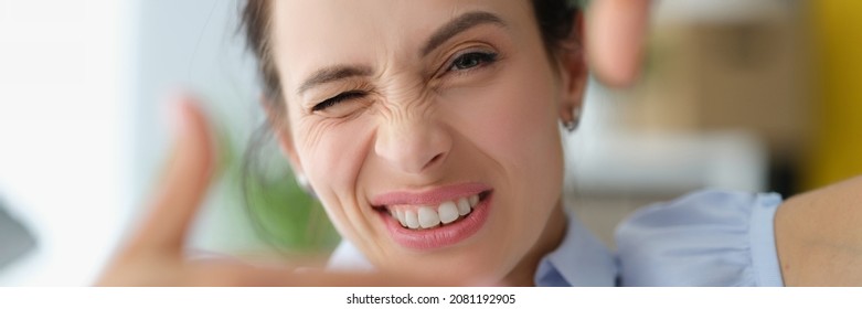 Young Woman Winks And Makes A Gesture With Hands To Photo Frame. Portrait Photography Concept